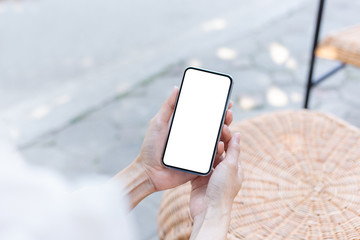 Mockup image blank white screen cell phone.woman hand holding texting using mobile on desk at coffee shop.background empty space for advertise text.people contact marketing business,technology