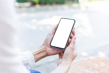 Mockup image blank white screen cell phone.woman hand holding texting using mobile on desk at coffee shop.background empty space for advertise text.people contact marketing business,technology