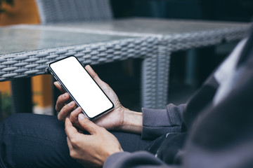 Mockup image blank white screen cell phone.woman hand holding texting using mobile on desk at coffee shop.background empty space for advertise text.people contact marketing business,technology