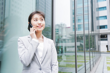 オフィス街で電話をする若いビジネスウーマン