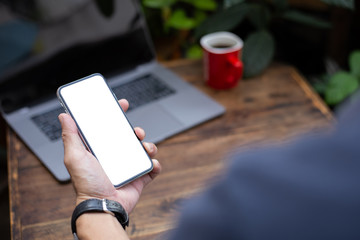 Mockup image blank white screen cell phone.woman hand holding texting using mobile on desk at coffee shop.background empty space for advertise text.people contact marketing business,technology