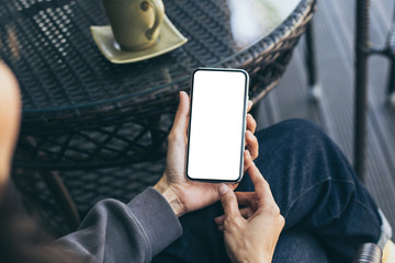 Mockup image blank white screen cell phone.woman hand holding texting using mobile on desk at coffee shop.background empty space for advertise text.people contact marketing business,technology