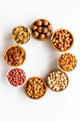 Nuts set in bowls on white background top-down frame copy space
