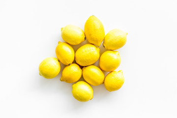 Ripe lemons - whole fruits - on white table top-down copy space