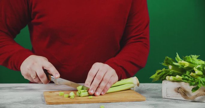 Man cuts celery on a cutting Board.