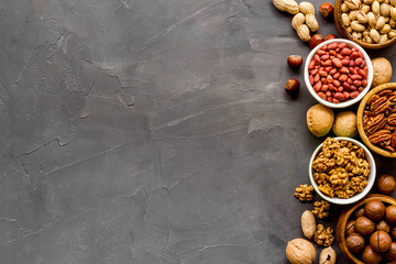 Set of macadamia, hazelnut, walnut, almond, pistachio, pecans nuts on grey background top-down frame copy space