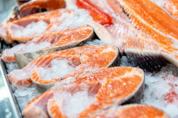 Chilled steaks of red fish. Pieces of fish lie on ice.