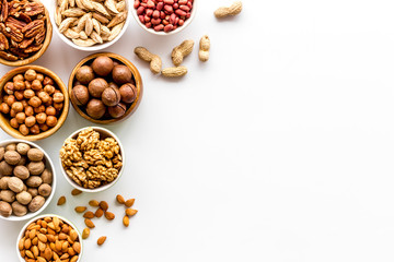 Set of macadamia, hazelnut, walnut, almond, pistachio, pecans nuts on white background top-down frame copy space