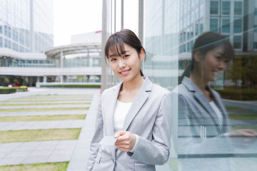 Fototapeta premium オフィス街でキャッシュレス決済をするビジネスウーマン