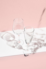 Empty glass. White table and pink wall.