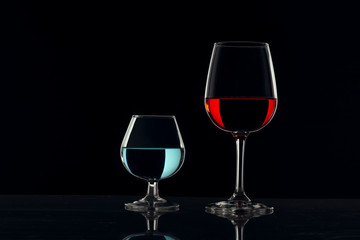 Copas de cristal con fondo negro y bebidas de color rojo y azul