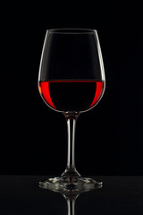 Copa de cristal con fondo negro y bebida de color rojo