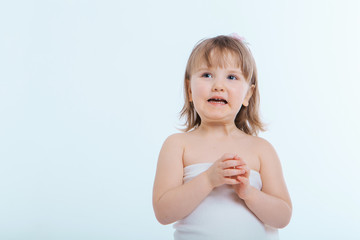 a little girl grimaces against a white background. The child is up to something. Concept of emotions , facial expressions, childhood, sincerity