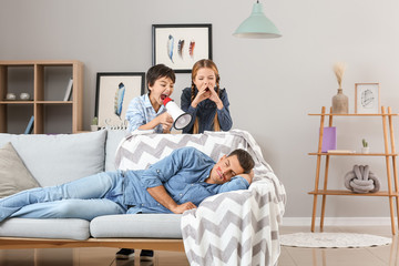 Children playing a prank on their father at home. April Fools' Day celebration