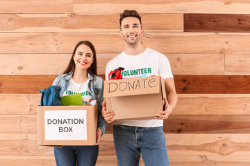 Volunteers with donations for orphans on wooden background