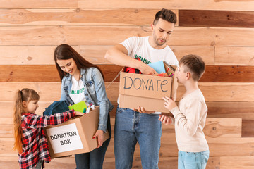 Volunteers with donations for orphans and little children on wooden background