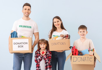 Volunteers with donations for orphans on color background