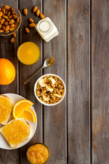 Vegetarian breakfast with granola and fruits on wooden background top-down frame copy space