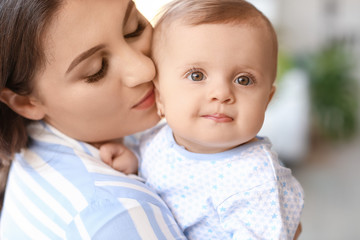 Happy mother with cute little baby at home