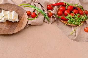 Tasty feta cheese with vegetables on color background