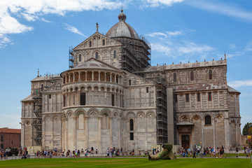 Fototapeta premium Tourists walk near the Leaning Cathedral of Pisa.