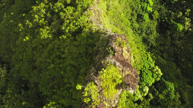 Breathtaking aerial footage over the spectacular view of Hawaiian coastal landscape lit by sunset from the side. Amazing volcanic rocks look epic. Blue ocean waves are seen washing the shore. 4K.