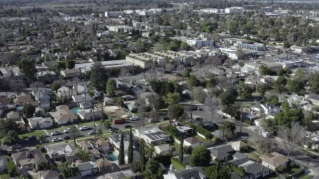 Aerial forward view of residential neighborhood houses during the day, Van Nuys, California
