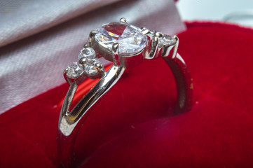 Silver ring with engagement diamonds in red box