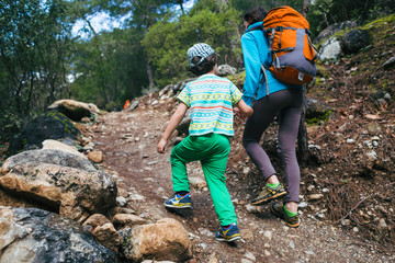 A woman walks with her son through the forest.
