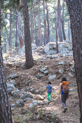 A woman walks with her son through the forest.