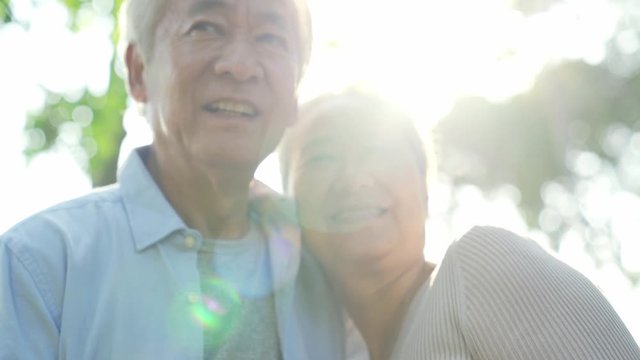 loving asian senior couple enjoying sunshine outdoors