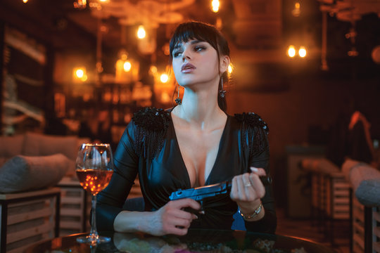 Portrait of a beautiful sexy woman with a gun in her hands.