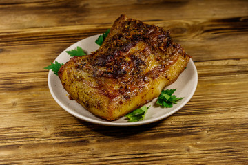 Baked pork belly in a plate on wooden table