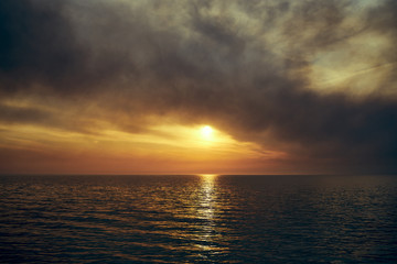 Sea sunset. Smoke wildfires sweeping across the sky.