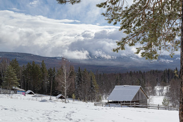 Winter landscape. Wooden hut in the middle of a snowy forest