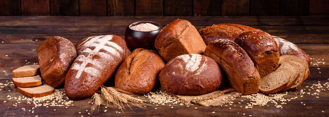 Fresh baked brown bread on a brown concrete background. Freshly baked traditional bread on a dark...