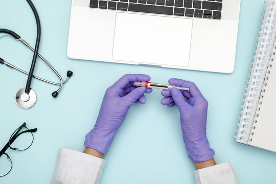 Doctor Sitting At Blue Office Desk And Working