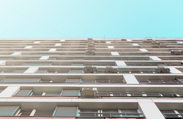 High rise residential buildings. The facade of a residential, apartment building with Windows and air conditioning under a clear blue sky on a Sunny day. Template, design.