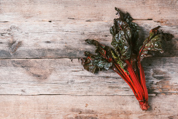 Multi-colored swiss chard on wooden background. Top view. Copy space. Zero waste, organic vegetables concept. Vegan and vegetarian diet food.