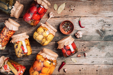 Сucumber, squash and tomatoes pickling and canning into glass jars. Ingredients for vegetables preserving. Healthy fermented food concept. Top view. Copy space.