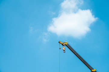 Hydraulic Mobile Crane against the blue sky and clouds. Industrial concept with copy space for wallpaper.