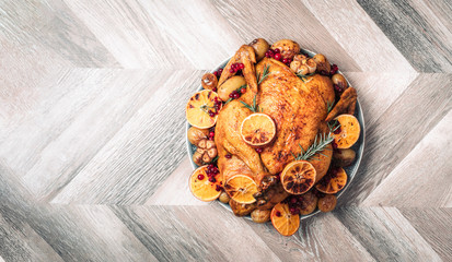 Whole roasted chicken with oranges, cranberries, spices and herbs. Copy space. Friends or family dinner. Festive Christmas table. Traditional Thanksgiving or Friendsgiving holiday celebration dish.