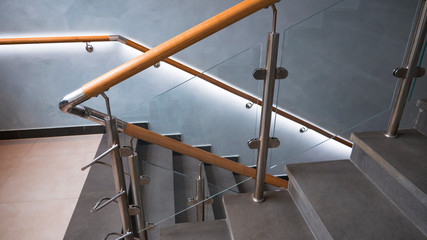 indoor staircase step with stainless steel and glass handrail.	