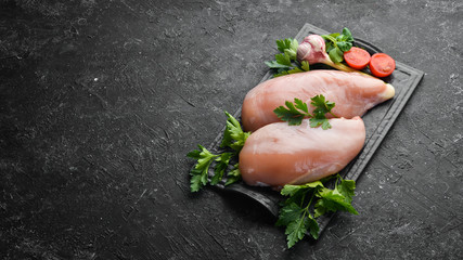 Raw chicken breast with parsley and spices on the table. Top view. Free space for your text. Rustic style. © Yaruniv-Studio