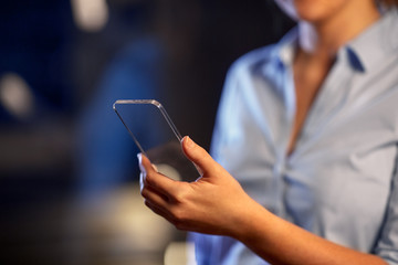 business, people and technology concept - close up of hand with transparent smartphone