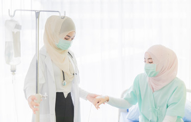 Female muslim doctor tack care for patient