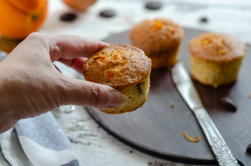 Delicious muffin with orange on a wooden table.