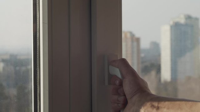 Caucasian male hand opening a window