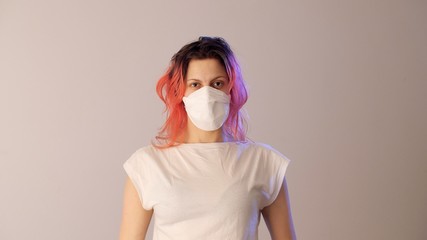 Portrait of a girl with pink hair in a protective medical mask. Stop coronavirus or covid-19 and the pandemic. 