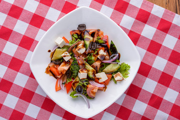 Dietary salad with vegetables, cheese feta, arugula and sauce. Traditional Italian cuisine, Italian concept.